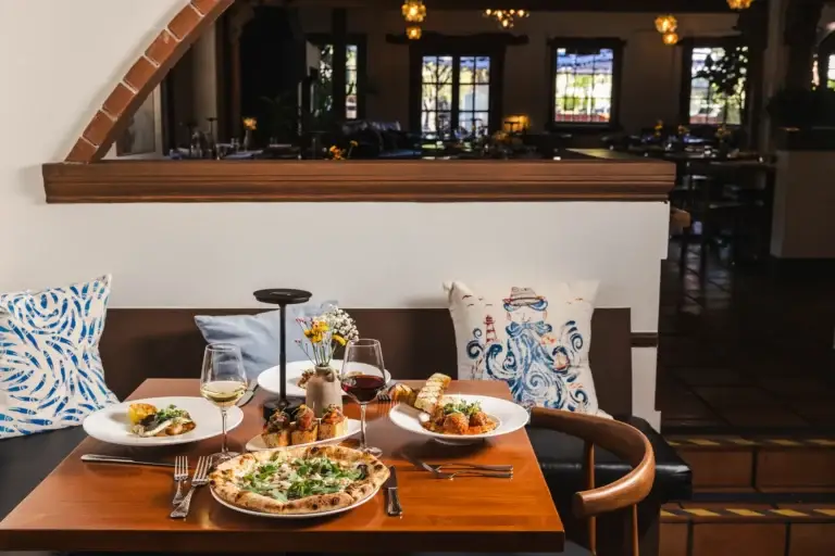 Contact 1 Booth with patterned pillows looking into the dining room of Capriciano Osteria, an Italian restaurant in downtown Santa Rosa