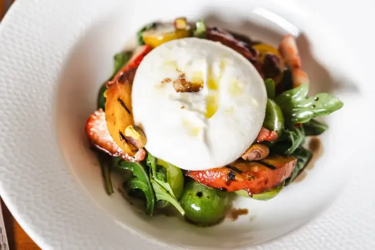 Blog 14 Close-up of Burrata Salad with grilled peach, strawberries, cherry tomatoes and arugula, from our Italian food and wine blog