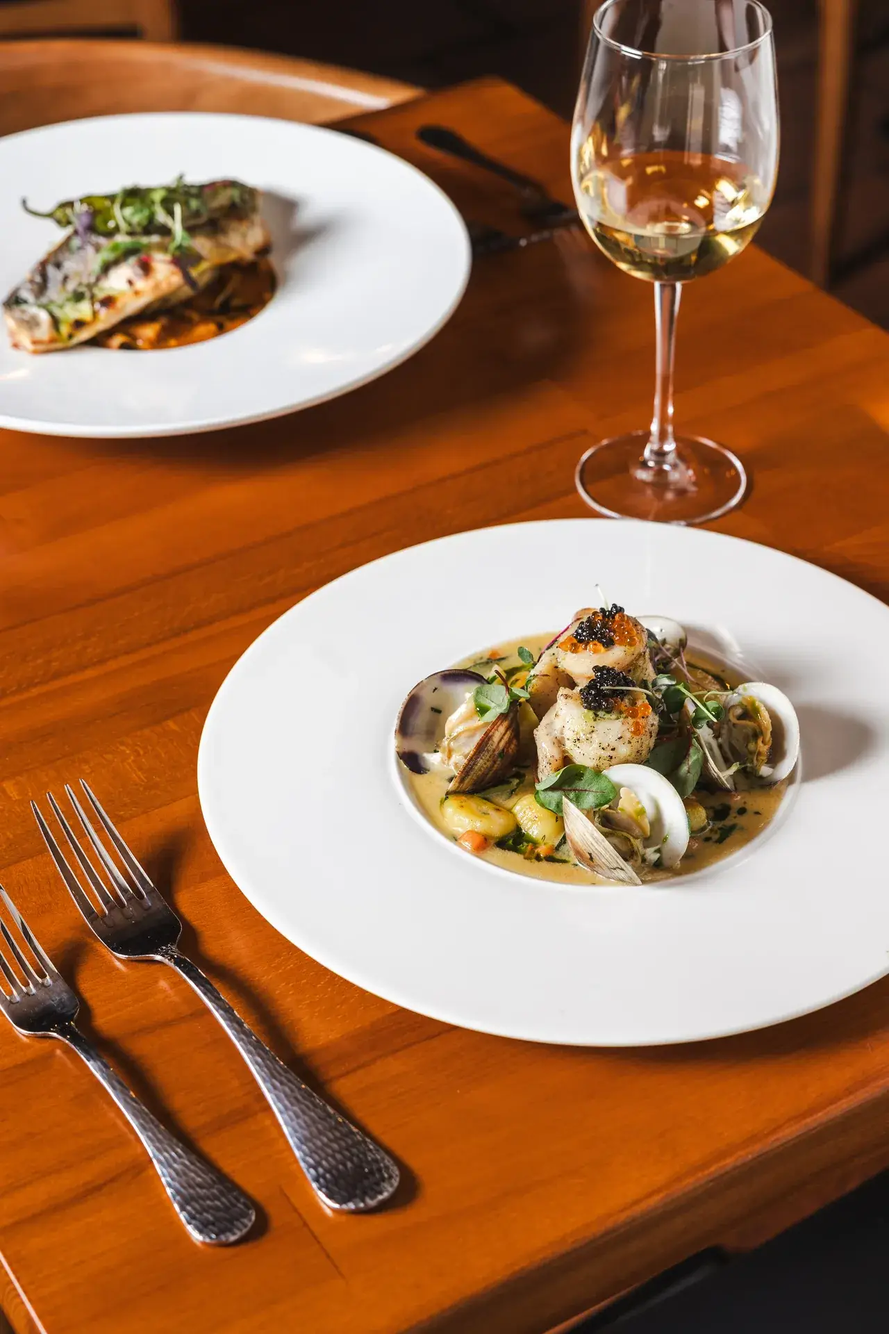 A Wine Pairing Guide for Italian Seafood 2 Fillet of Petrale Sole with clams and caviar beside a glass of white wine at Capriciano Osteria