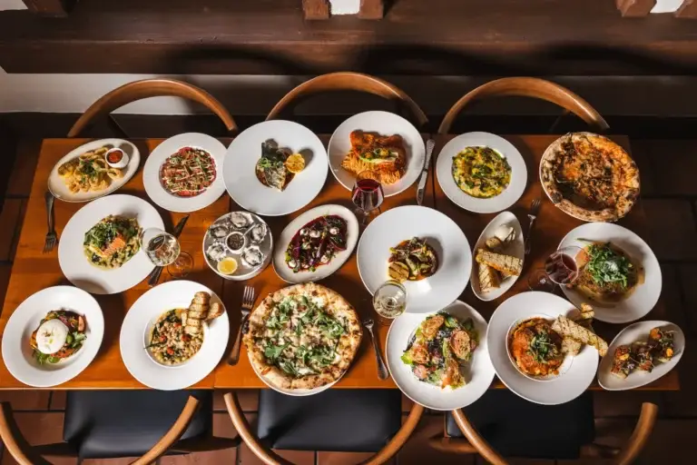 Long table set with shared Italian dishes and wine for private dining in Santa Rosa at Capriciano Osteria