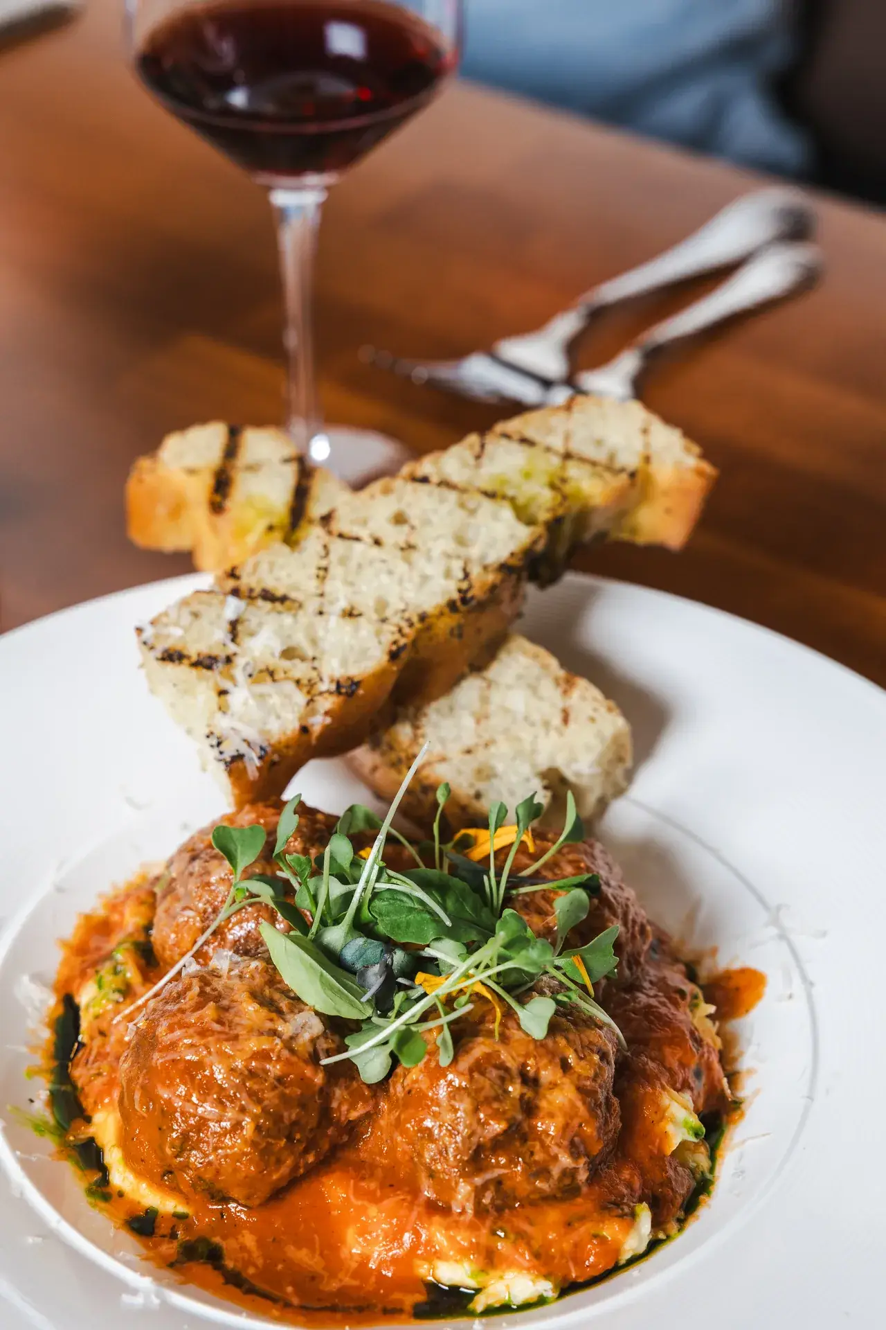Mamma Eleni's Meatballs in tomato sauce with grilled bread and red wine at Capriciano Osteria