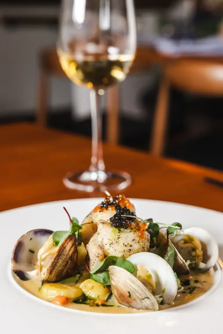 Drink Menu 3 A glass of white wine with petrale sole, clams and caviar at Capriciano Osteria