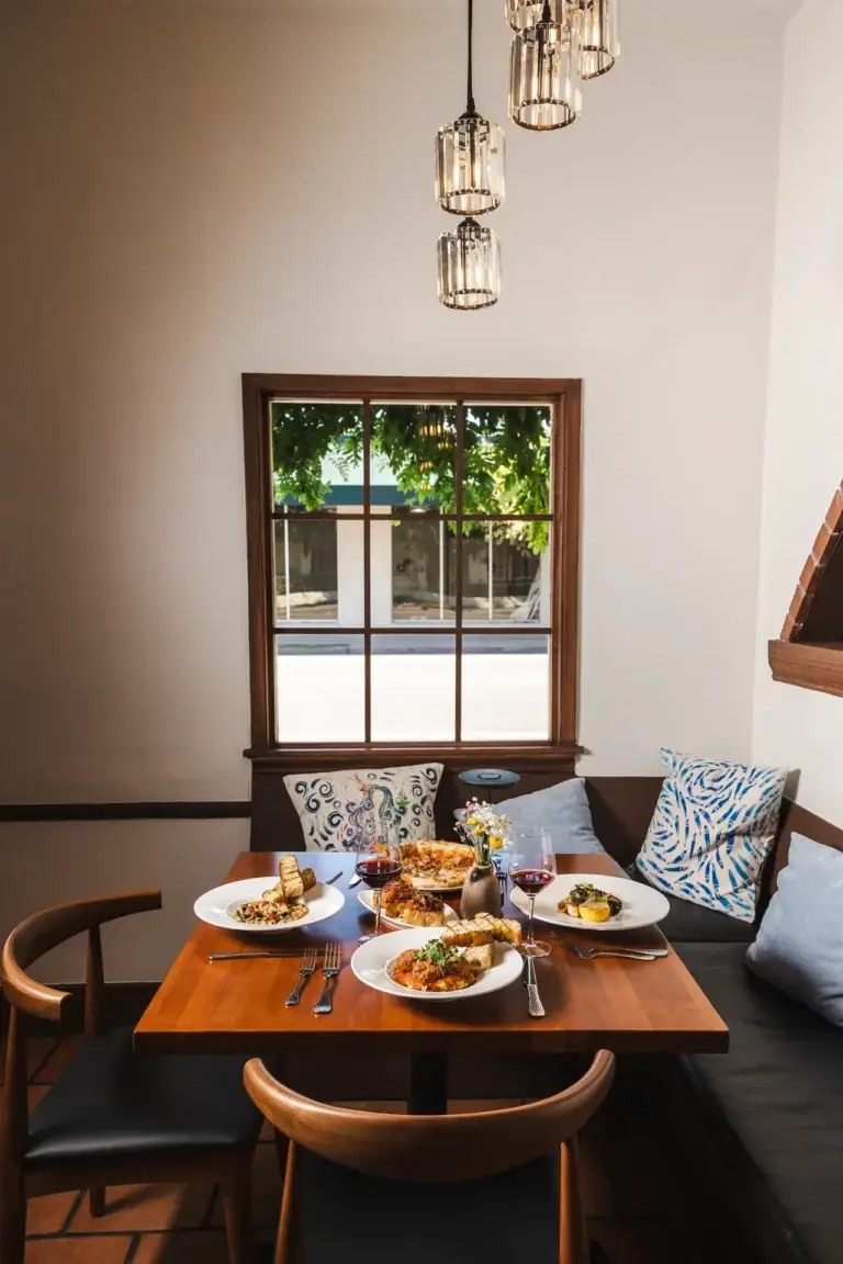 Make a Reservation 2 Window booth set for dinner, ready for Italian restaurant reservations in Santa Rosa at Capriciano Osteria
