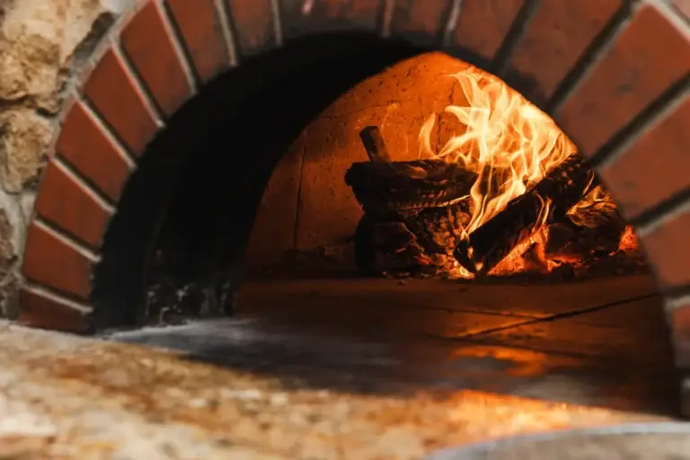 Wood-fired pizza oven with a live fire at Capriciano Osteria