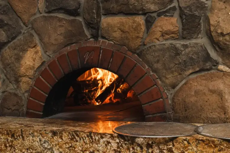Firewood Oven Pizza 1 Wood-fired pizza oven with a brick arch and a live fire, where we bake wood-fired pizza in Santa Rosa at Capriciano Osteria
